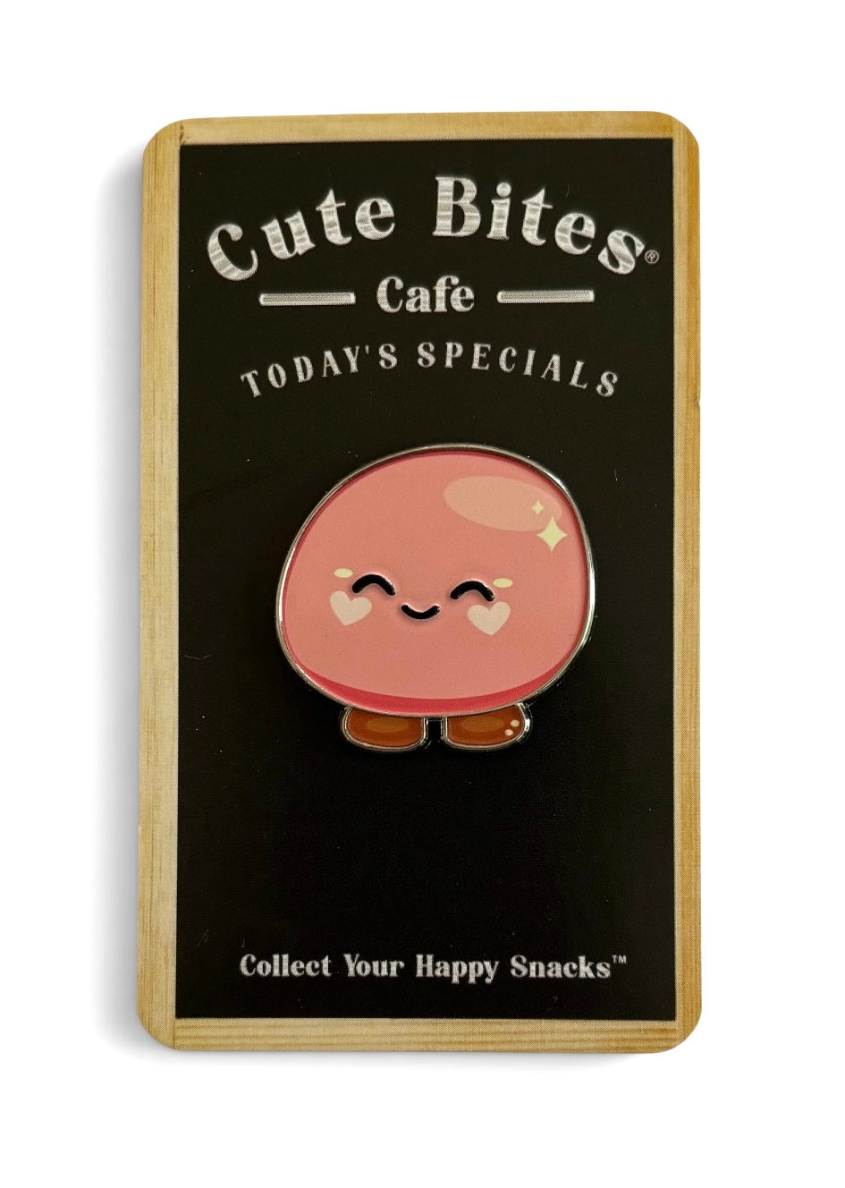A cute pink round gentle mochi enamel pin with a smiling face and small brown feet, mounted on a black display card with the brand name 'Cute Bites Cafe' and the text 'TODAY'S SPECIALS'.